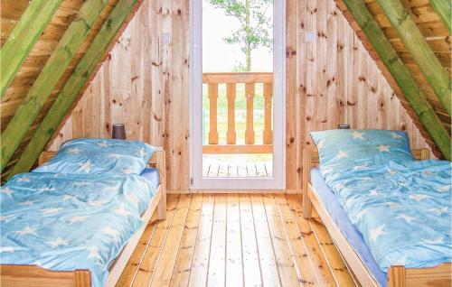 OsiekiにあるBeautiful Home In Osieki With House Sea Viewのウッドルーム ベッド2台 窓付