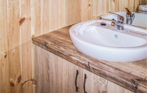 a bathroom with a white sink and wooden cabinets at Awesome Home In Osieki With 2 Bedrooms And Wifi in Osieki