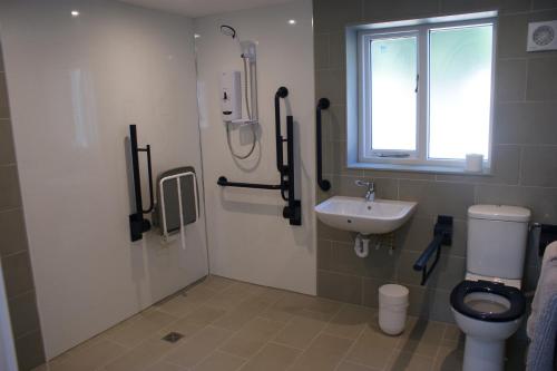 a bathroom with a toilet and a sink at Spacious 4 bed family cottage in parkland setting in York