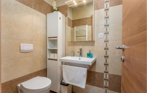 a bathroom with a sink and a toilet and a mirror at 2 Bedroom Nice Apartment In Kornic in Kornić