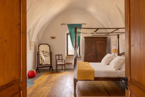 a bedroom with a canopy bed and a mirror at Masseria San Paolo Grande in Ostuni