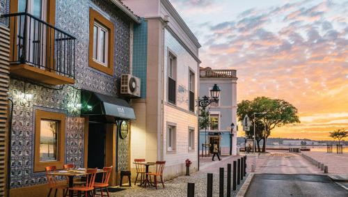 a street with a table and chairs and a building at Apartamento remodelado no Seixal in Seixal
