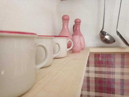 a row of pink and white vases on a kitchen counter at Dolomiti House in Cencenighe