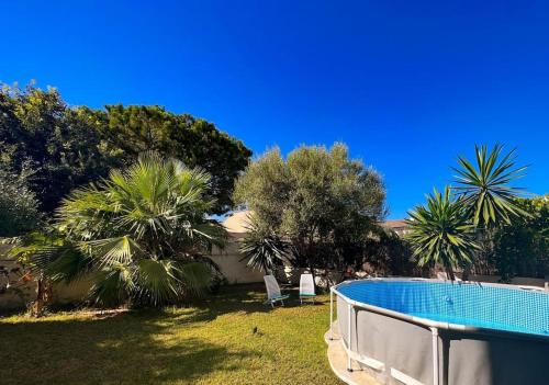 una piscina en un patio con palmeras en Ca Na Fulla. Agradable casa con jardín y piscina., en Colonia de San Pedro
