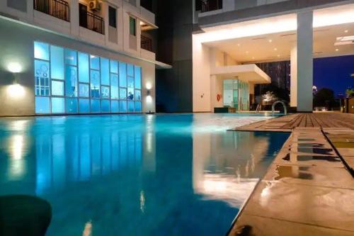 a large swimming pool in a building with blue water at CENTRAL JAKARTA HOMESTAY FAST WIFI in Jakarta