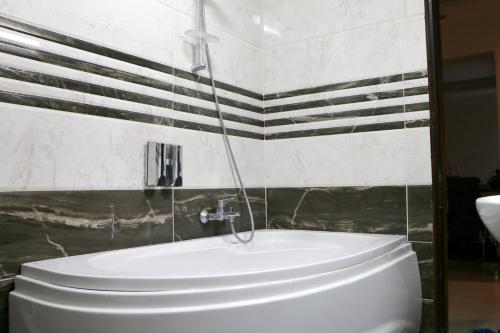 La salle de bains est pourvue de toilettes blanches et de carrelage noir. dans l'établissement Red Flower in Palm City compound 1 hour to the sea, au Caire