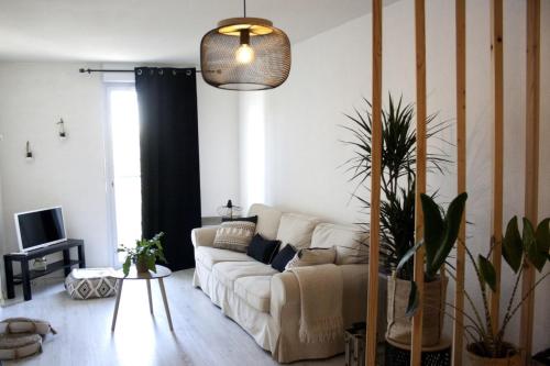 uma sala de estar com um sofá branco e uma mesa em Perigueux T2 proche du quartier historique em Périgueux
