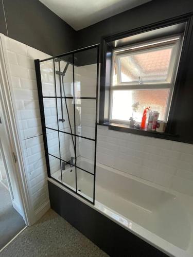 a bathroom with a glass cabinet and a window at 1 bed flat with parking near town centre in Emsworth