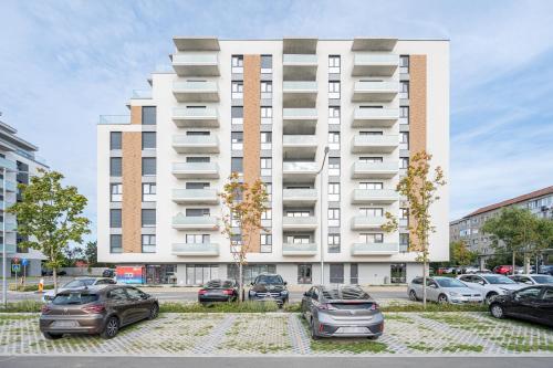 a large white building with cars parked in front of it at Map Flat in Oradea