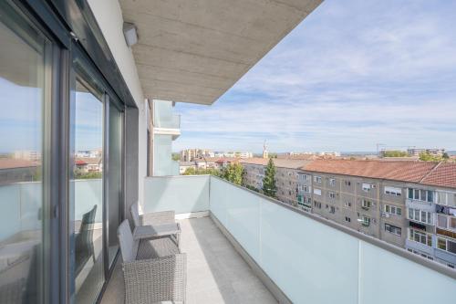 a balcony with two chairs and a view of a building at Map Flat in Oradea