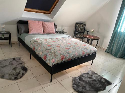 ein Schlafzimmer mit einem Bett, zwei Tischen und einem Stuhl in der Unterkunft Le cocon d'Emma in Sélestat