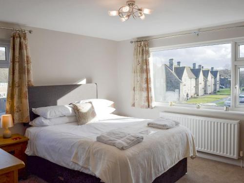 a bedroom with a bed and a large window at Wyedale in Bakewell