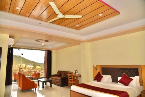 a bedroom with a bed and a ceiling fan at Jai Hotel By Boho in Pālampur