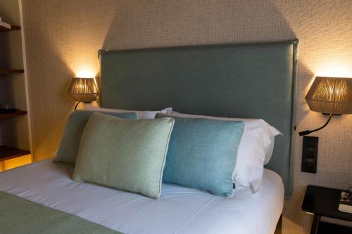 a bed with a green headboard and two lamps at Casa Rural San Andrés de Teixido in Cedeira