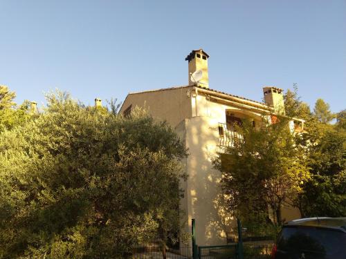 een oud gebouw met bomen ervoor bij Jolie maison de village, à 2 min à pied du lac d'Esparron de Verdon in Esparron-de-Verdon