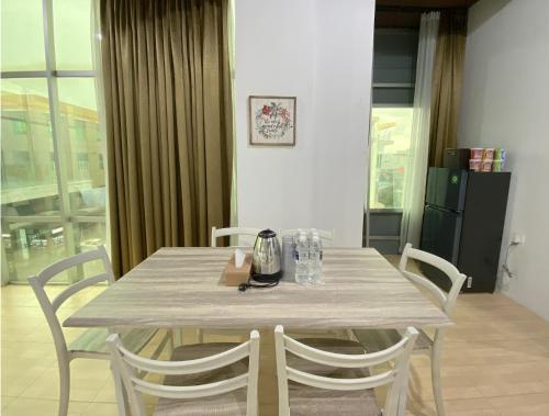a table with chairs and a tea kettle on it at CN Homestay C2 Floor 3 at Nagoya Hill Mall in Nagoya