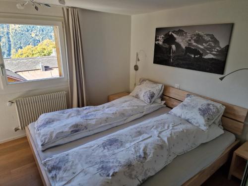 2 Betten in einem Zimmer mit Fenster in der Unterkunft Chalet Viola - Verena's Loft in Wengen