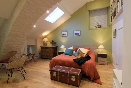 ein Schlafzimmer mit einem großen Bett mit einer roten Tagesdecke in der Unterkunft Le clair de lune in Millau