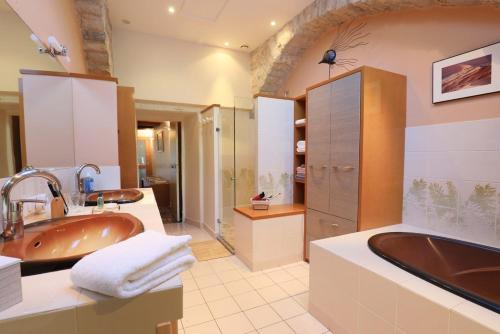 ein Badezimmer mit einer großen Badewanne und einem Waschbecken in der Unterkunft Le clair de lune in Millau