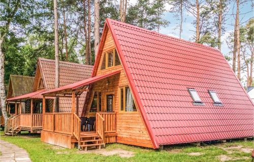 Cabaña de madera con techo rojo en Holiday Home Lukecin Ulsloneczna, en Łukęcin