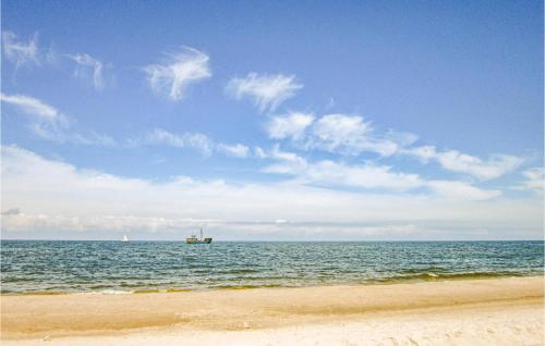 una vista del océano con un barco a lo lejos en Holiday Home Lukecin Ulsloneczna, en Łukęcin