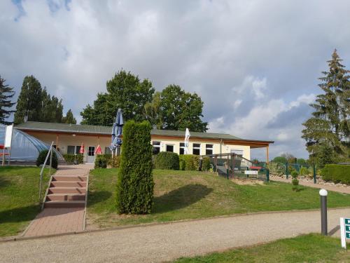 a house with a pathway leading to it at Ferienanlage - Zum See & Hotel in Plau am See