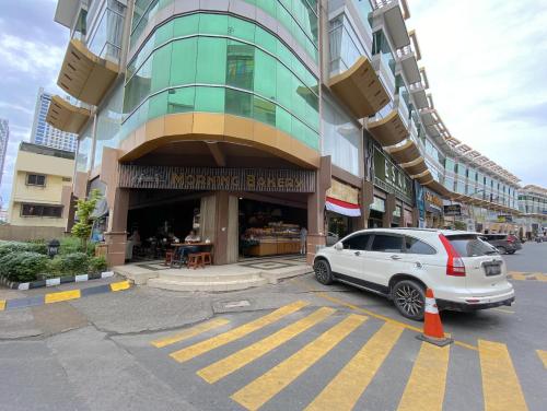 a white car parked in front of a building at CN Homestay A1 Floor 1 at Nagoya Hill Mall in Jodoh