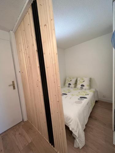 une chambre avec un lit et un mur en bois dans l'établissement Appartement 2 pièces en rez de jardin avec parking et piscine, à Villeneuve-Loubet