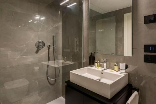 ein Badezimmer mit einem weißen Waschbecken und einer Dusche in der Unterkunft Casa Parboni in Rom