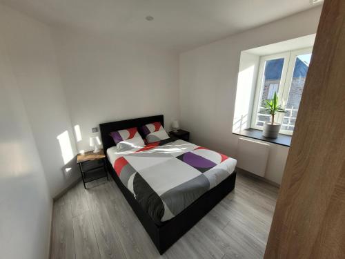 een slaapkamer met een bed en een groot raam bij Aux portes du Mont in Saint-James