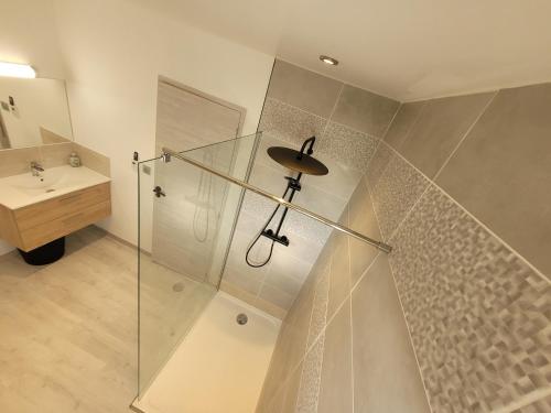 een badkamer met een glazen douche en een wastafel bij Aux portes du Mont in Saint-James