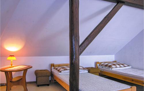 KarsibórにあるStunning Apartment In Swinoujscie With 4 Bedroomsの二段ベッド2台とテーブルが備わる客室です。