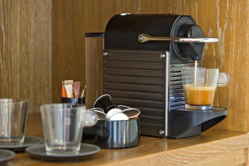a coffee maker sitting on a counter with two glasses at Kydon The Heart City Hotel in Chania Town