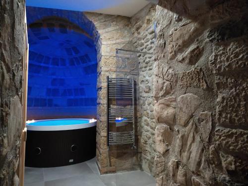 y baño con bañera en una pared de piedra. en Casa Patou, en Ponte