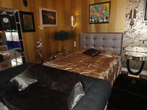a bedroom with a bed and a couch in it at Boudoir Budapest Apartment in Budapest