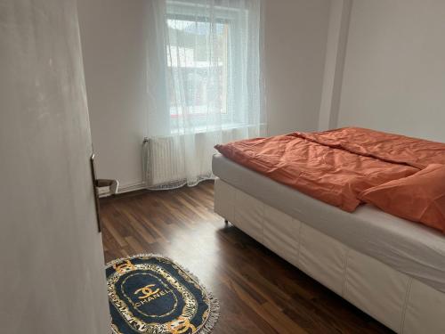 a bedroom with a bed and a wooden floor at Ferienwohnung C&C in Trofaiach