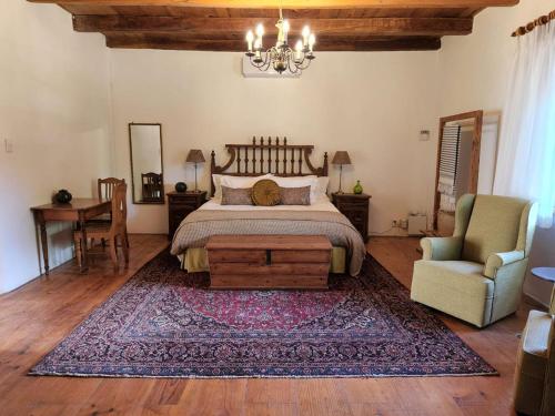 um quarto com uma cama, uma mesa e uma cadeira em Yellowwood House em Tulbagh