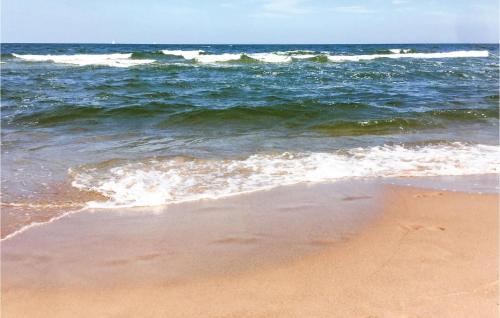 a beach with the ocean and the waves at Nice Stacaravan In Retowo 4 in Gardna Wielka