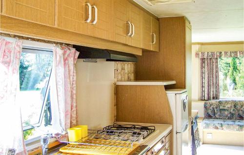 a kitchen with a stove top oven next to a window at Lovely stacaravan In Darlowo With Kitchen in Darłowo