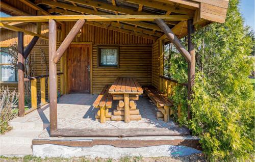 a wooden cabin with a picnic table in front of it at 1 Bedroom Stunning Home In Wilczeta in WilczÄ™ta