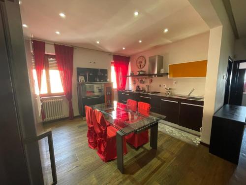 a kitchen with a table and red chairs in it at Residenza MaryLou in Porto SantʼElpidio
