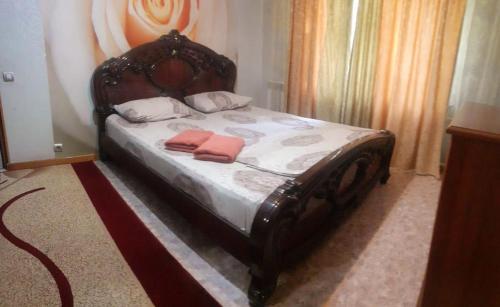 a bed with two pillows on it in a room at Иляева 66 парк Кен Баба in Shymkent