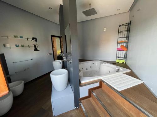 a bathroom with a tub and a toilet and a sink at Residenza MaryLou in Porto SantʼElpidio