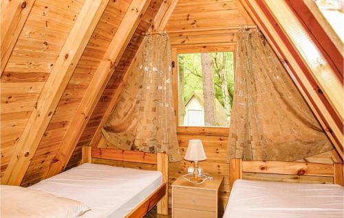 a bedroom with two beds in a log cabin at Gorgeous Apartment In Lukecin With Kitchen in Łukęcin