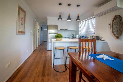 a kitchen with a wooden table and a dining room at Holiday House in Brisbane