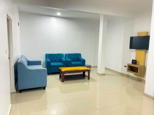 een wachtkamer met twee blauwe stoelen en een tafel bij Rebero View Apartments in Kigali