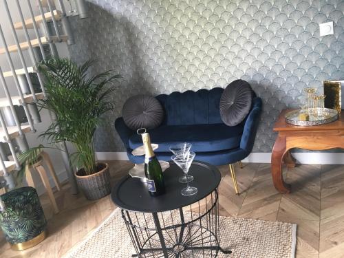 a living room with a blue couch and a table at La petite Brainoise - Gîte avec salle jacuzzi 120 jets in Braine