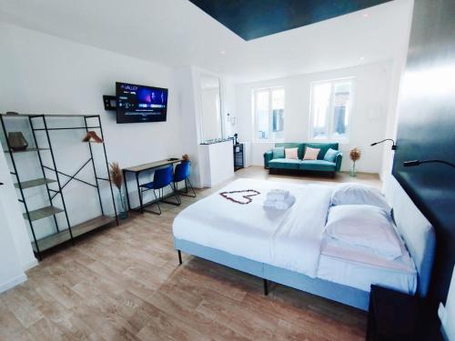 - une grande chambre avec un lit et un canapé dans l'établissement NG SuiteHome - Lille I Tourcoing Winoc - Balnéo - Netflix - Wifi, à Tourcoing