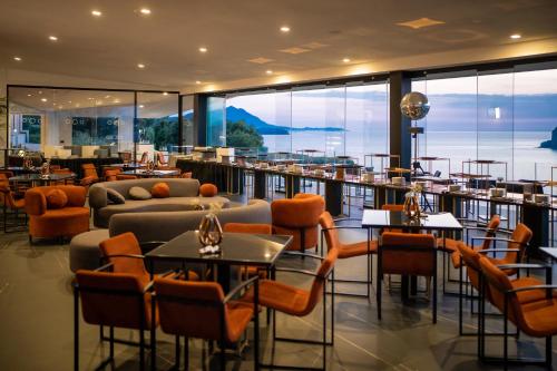 a restaurant with couches and tables and chairs at Hotel Cala Moresca in Bacoli