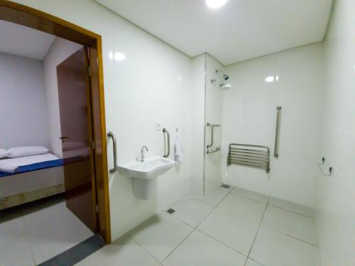 a bathroom with a sink and a toilet and a bed at HOTEL CONSAGRADO in Aparecida